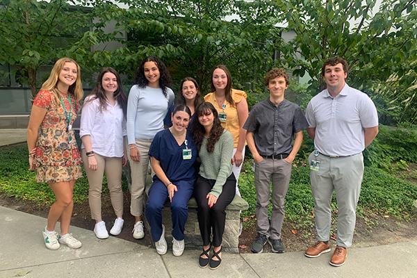 A group of college students standing outside of a Dartmouth Health building