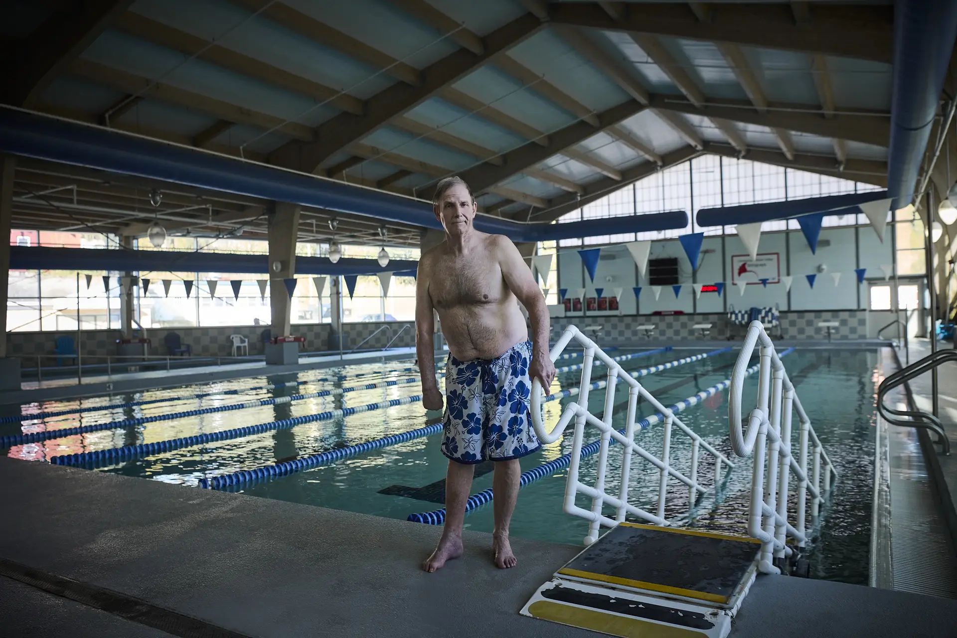 Patient Chris Burge standing at indoor swimming pool