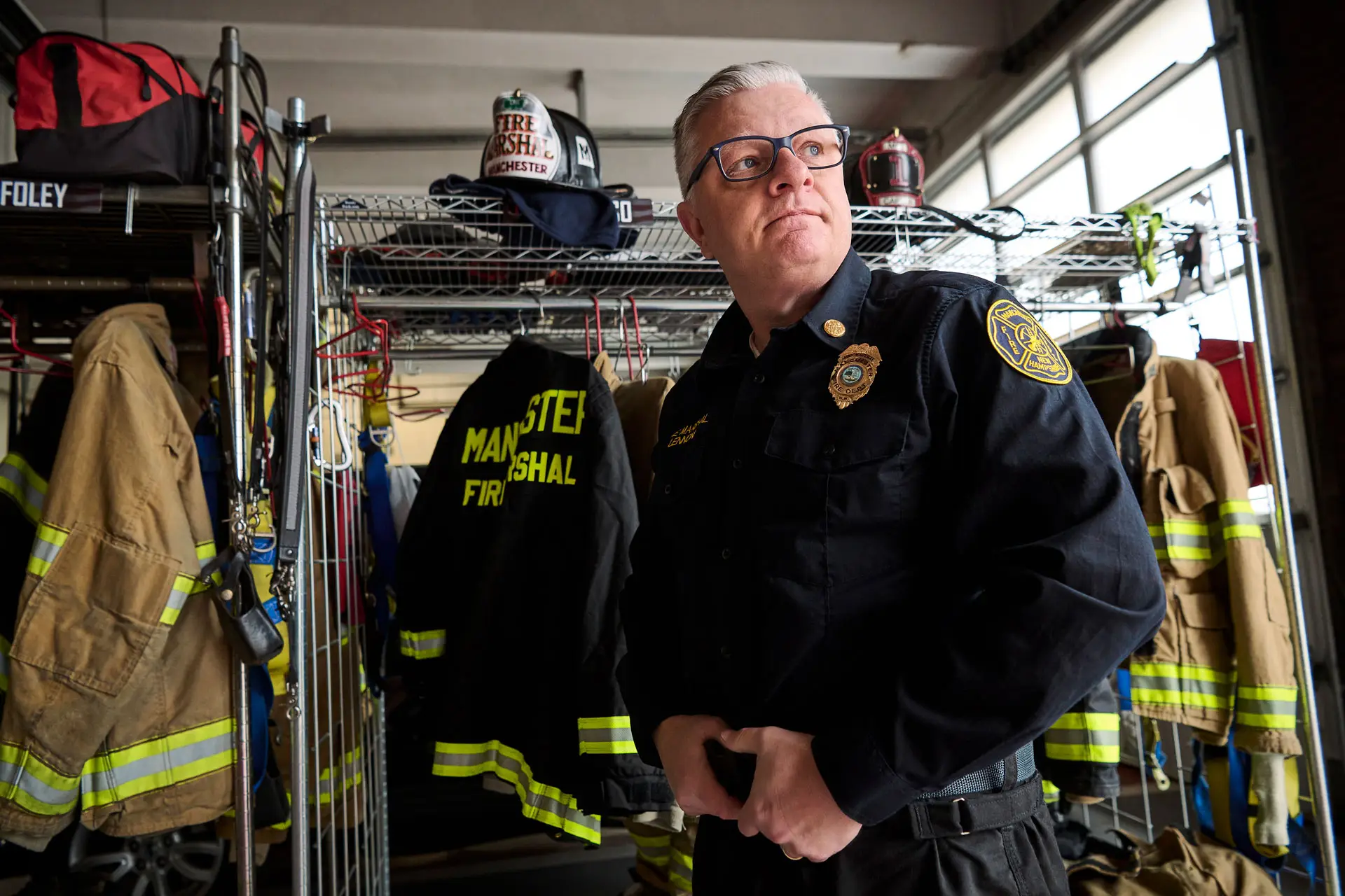 Patient Peter Lennon standing in front of firefighting equipment