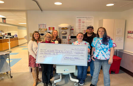 Cheshire Medical Center staff, Jen and Dan Clayman and a family friend stand with donation check
