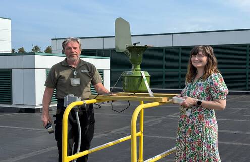 Bruce Spencer and Erin Reigh standing on DHMC roof with pollen counter