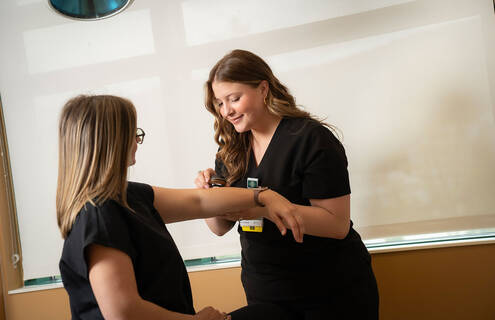 Female clinician examining forearm of female patient