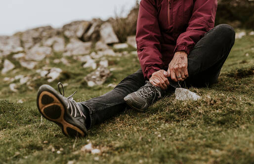 close up of a seated person massaging their ankle