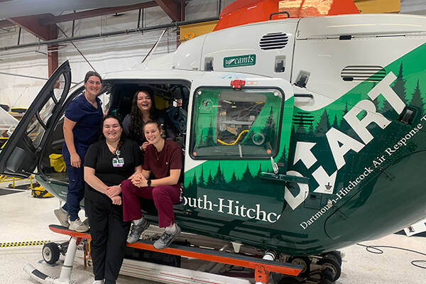 Intern students posing with a DHART helicopter