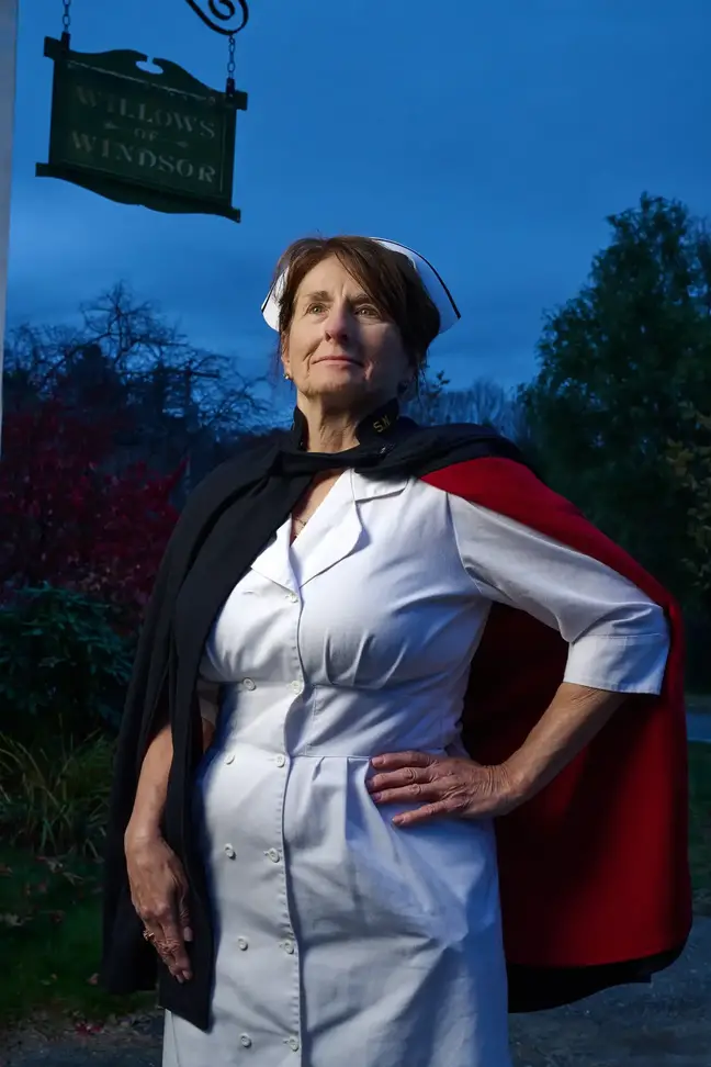 Nurse Susan Januszewski stands outside in her traditional nurses uniform under a sign that says Willows Windsor