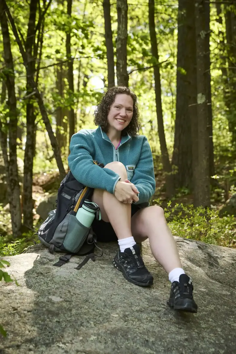 Krystal Kebler sits down from a break while hiking in the woods