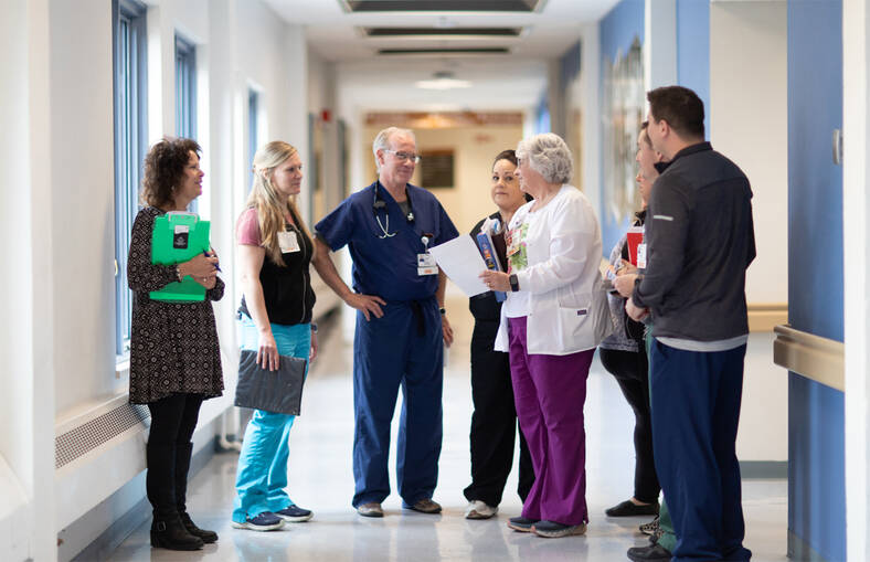 Healthcare providers having a conversation in a hospital hallway